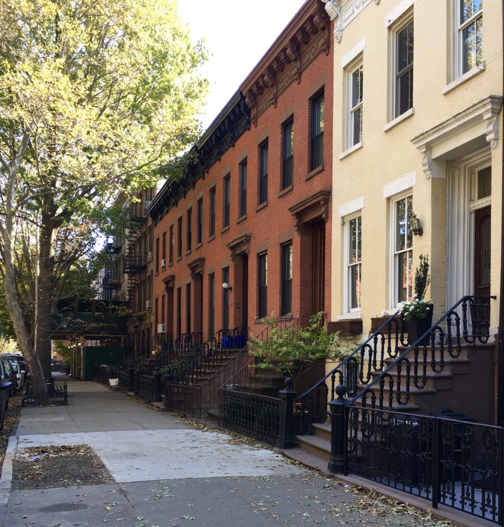 This brick row includes creamy-hued 110 Bergen St. (at right) and red-brick 112 through 118 Bergen St. Eagle photo by Lore Croghan