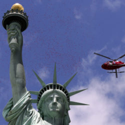 A helicopter showers rose petals over the Statue of Liberty on D-Day 2014. AP file photo by Richard Drew
