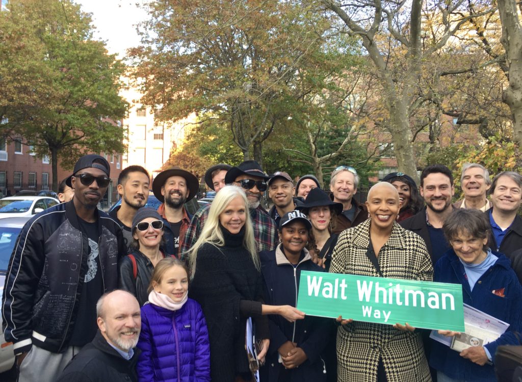 City Councilmember Laurie Cumbo holds a Walt Whitman Way street sign. New York University Professor Karen Karbiener, who’s wearing a black poncho, stands at left. Eagle photo by Lore Croghan
