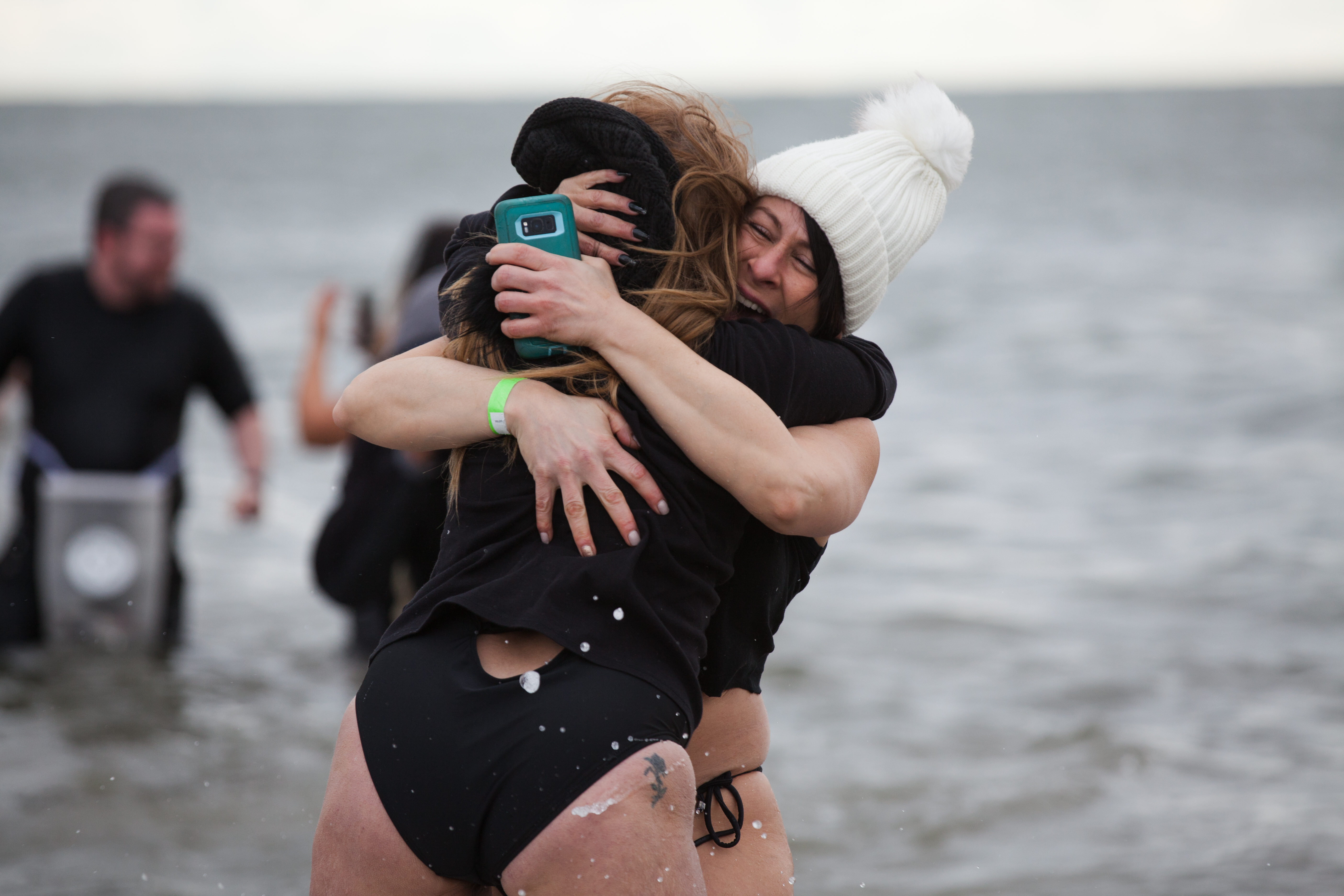 Two friends embrace in the water.