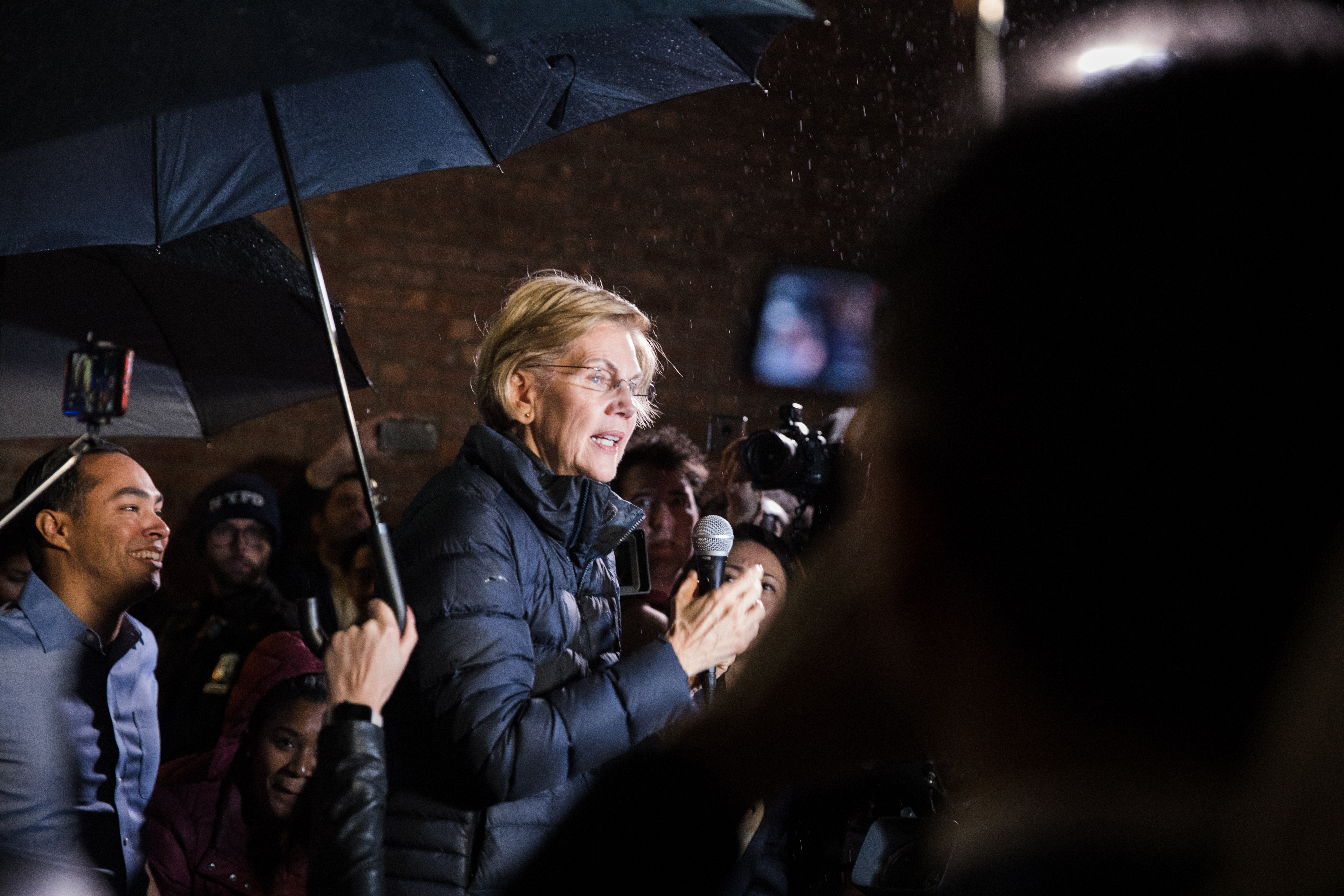 Before entering the theater, Warren gave an impromptu speech to an overflow crowd in the rain.