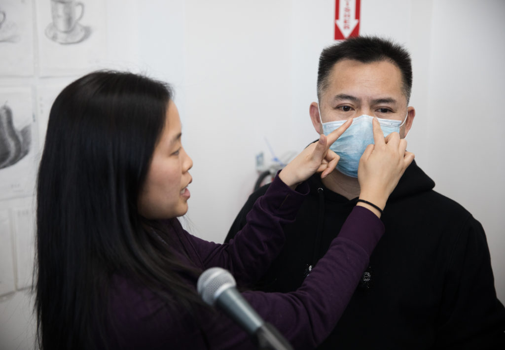 A health professional explains how a medical mask must fit in order to be protective. Photo: Paul Frangipane/Brooklyn Eagle