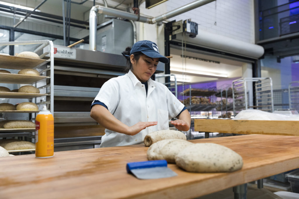 A baker at Russ & Daughters’ Navy Yard facility preps loaves of bread for the oven. Photo: Paul Frangipane/Brooklyn Eagle