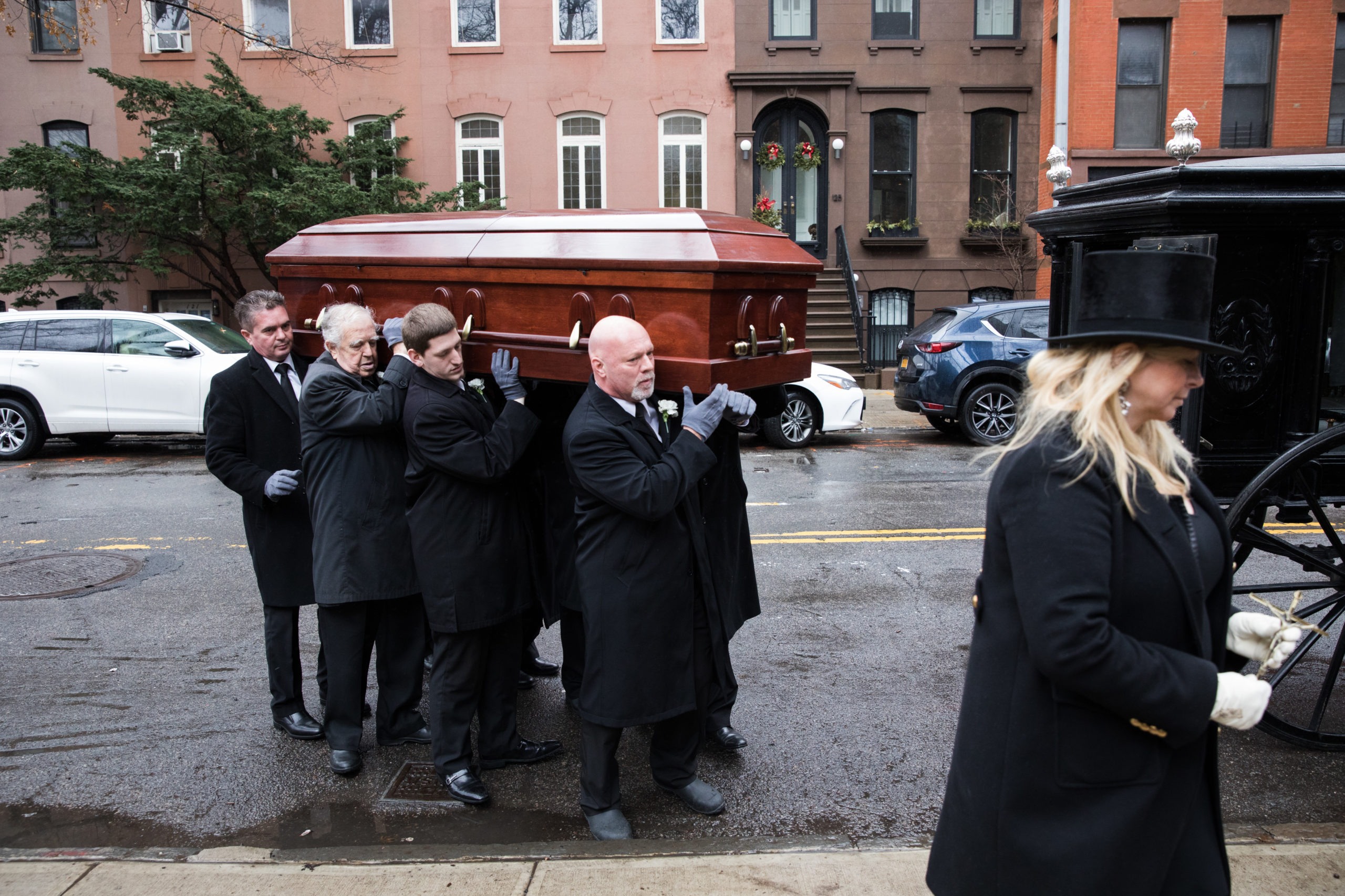 Pallbearers remove the casket from the hearse to bring it into St. Augustine's RC Church for mass.
