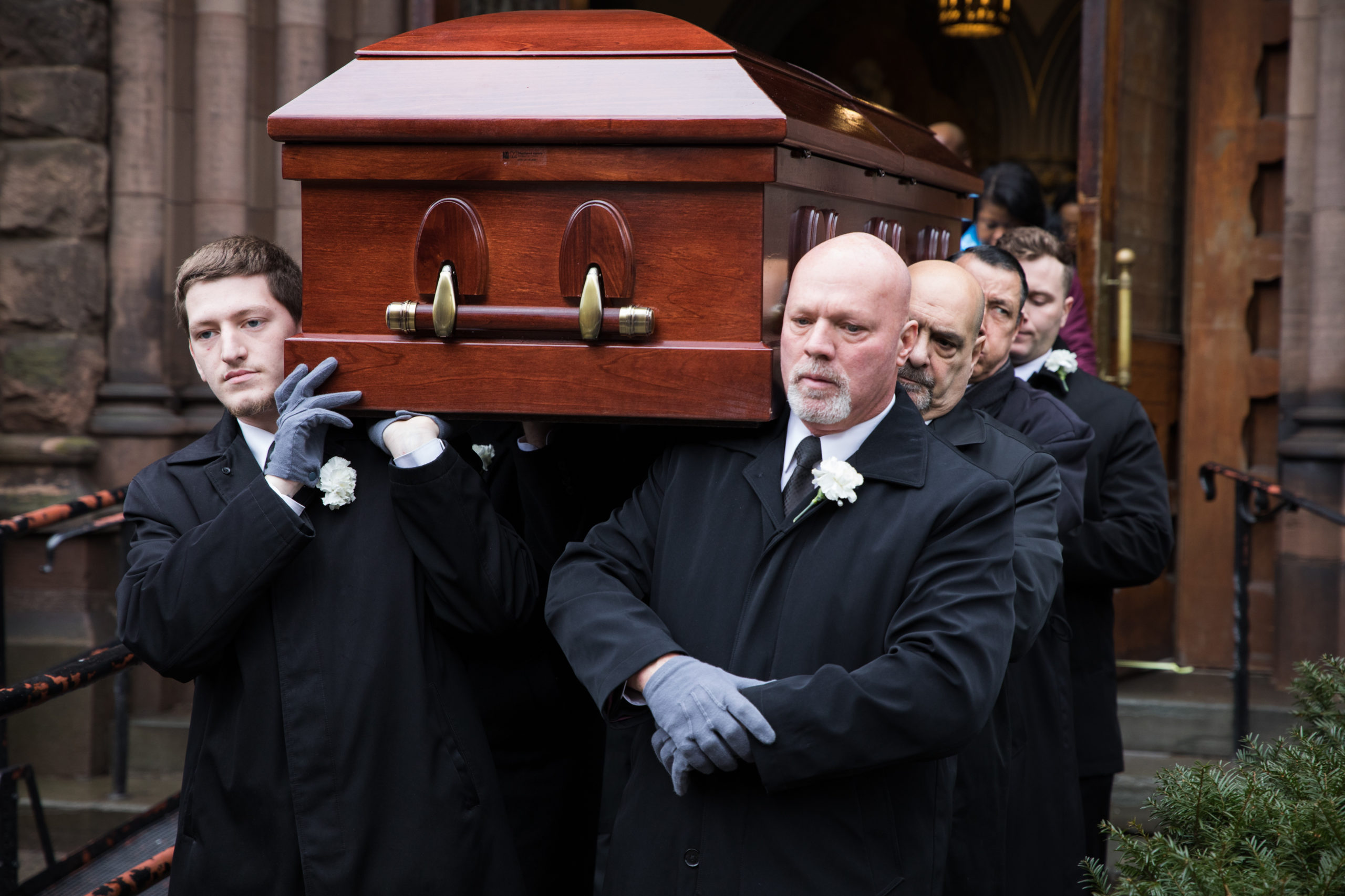 Pallbearers bring the casket to the hearse to bring it to Green-Wood Cemetery. 