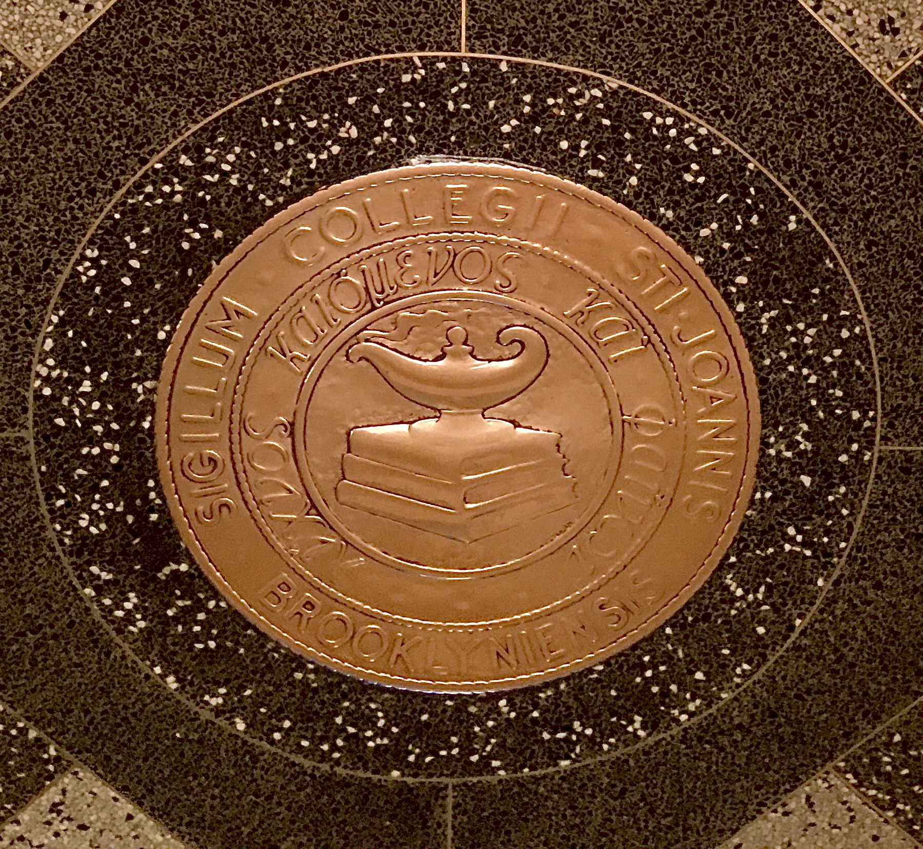 This decoration embedded in the lobby floor of 96 Schermerhorn St. harkens back to the building’s days as St. John’s University School of Law. Photo: Lore Croghan/Brooklyn Eagle