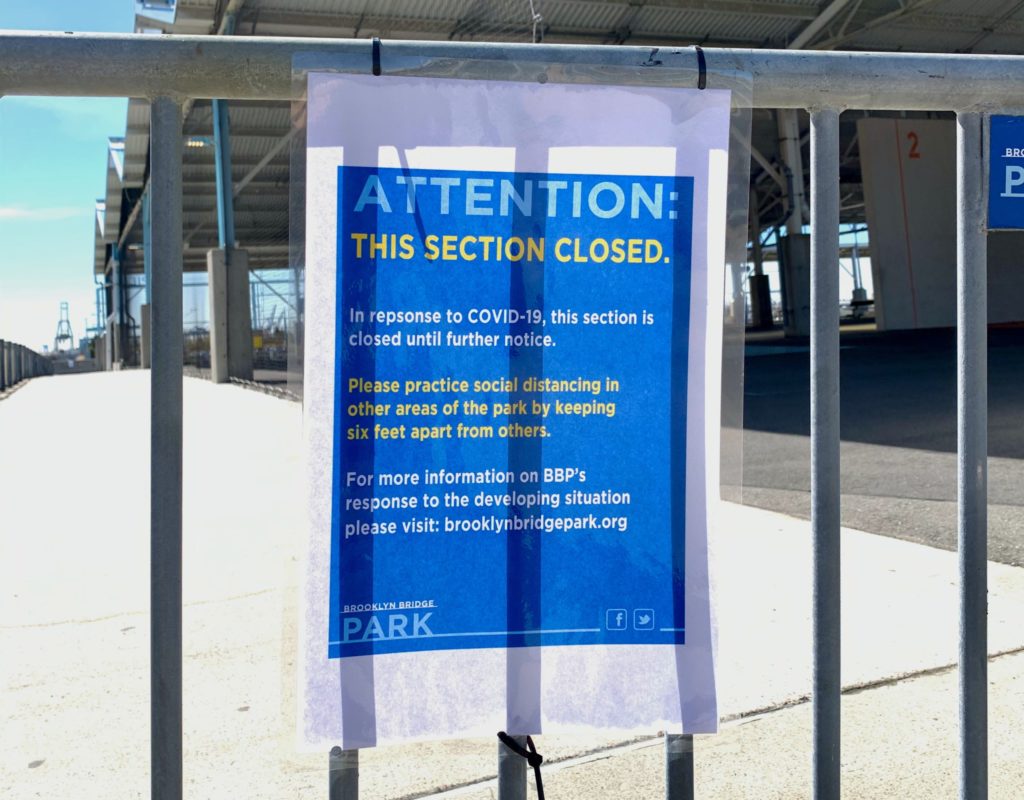 A sign at Brooklyn Bridge Park warns that team sports and close contact in parks is forbidden during the coronavirus pandemic. Mayor de Blasio said Tuesday if people can’t keep at least six feet apart, he might move to shut down playgrounds. Photo: Mary Frost/ Brooklyn Eagle