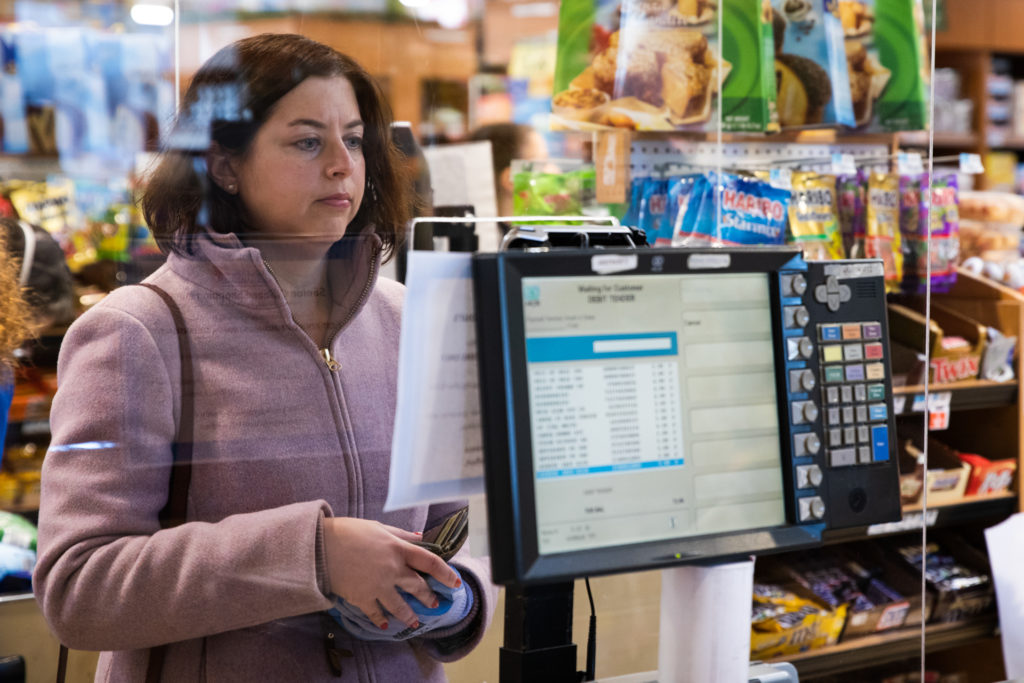 Nicole Mirra, a volunteer with Bay Ridge Cares, grocery shops for a couple in Bay Ridge who can’t leave their home. At the supermarket where she’s shopping, employees put up plexiglass windows to separate the cashiers from the customers. Photo: Paul Frangipane/Brooklyn Eagle