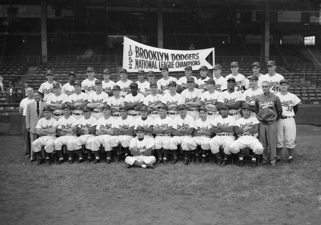The Brooklyn Dodgers, National League champions, pose for a team photo, Sept. 26, 1952, at Ebbets Field, Brooklyn. Seated on ground: Charlie Di Giovanna. Seated in first row, from left: George Shuba, Andy Pafko, Pee Wee Reese, George Pfister, Cookie Lavagetto, Chuck Dressen, Jake Pitler, Billy Herman, Billy Cox, Roy Campanella, Carl Furillo, Dr. Harold Wendler. Second row: John Griffin (in T-shirt), Lee Scott (in suit), Jim Hughes, Gil Hodges, Ben Wade, Johnny Rutherford, Jackie Robinson, Clem Labine, Clyde King, Chris van Cuyk, Preacher Roe, Joe Black, Ralph Branca, Rocky Nelson. Last row: Joe Landrum, Ed Amoros, Rube Walker, Carl Erskine, Bobby Morgan, Tommy Holmes, Rocky Bridges, Billy Loes, Duke Snider, Dick Williams, Ken Lehman, Ronnie Negray, Steve Lembo, Ray Moore.