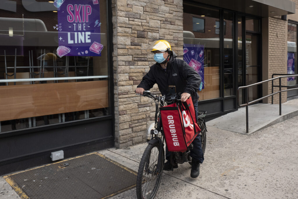 A delivery man bikes with a food bag from Grubhub on April 21, 2021, in New York.