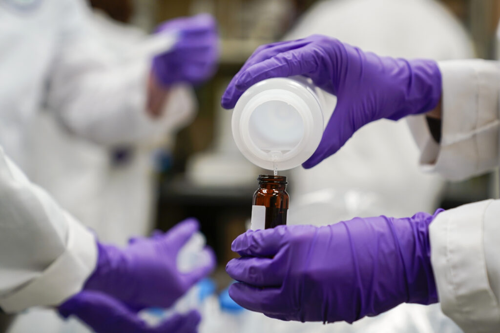 Eva Stebel, water researcher, pours a water sample into a smaller glass container for experimentation as part of drinking water and PFAS research at the U.S. Environmental Protection Agency Center For Environmental Solutions and Emergency Response, Feb. 16, 2023, in Cincinnati. Photo: Joshua A. Bickel/AP