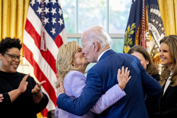 <b>WHITE HOUSE — Sealed with a kiss:</b> President Joe Biden, accompanied by Office of Management and Budget director Shalanda Young, left, and Women's Alzheimer's Movement founder Maria Shriver, right, gives first lady Jill Biden a kiss after giving her the pen he used to sign a presidential memorandum that will establish the first-ever White House Initiative on Women's Health Research in the Oval Office of the White House, Monday, Nov. 13, 2023, in Washington.<br>Photo: Andrew Harnik/AP