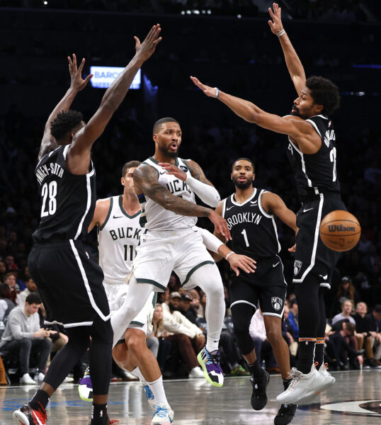 <strong>BROOKLYN — Making a pass under a high wall of Nets:</strong> Milwaukee Bucks guard Damian Lillard, center, passes the ball away from Brooklyn Nets forward Dorian Finney-Smith (28), guard Spencer Dinwiddie, right, and forward Mikal Bridges (1) during the second half of an NBA basketball game, Monday, Nov. 6, 2023, in New York.<br>Photo: Noah K. Murray/AP