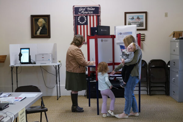 <strong>OHIO — George Washington on the wall, open polls will give hints of next year’s key presidential race:</strong> Lauren Miracle, right, holds her son Dawson, 1, as she helps her daughter Oaklynn, 3, fill out a child's practice ballot before voting herself at a polling location in the Washington Township House in Oregonia, Ohio, Tuesday, Nov. 7. Polls are open in a few states for off-year elections that could give hints of voter sentiment ahead of next year's critical presidential contest.<br>Photo: Carolyn Kaster/AP