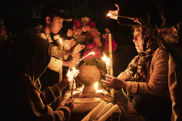 MEXICO — Halloween concepts have more gravitas in Mexico, as they celebrate, and pay tribute to those that have been lost: People hold candles over a tomb decorated with flowers at a cemetery in Atzompa, Mexico, late Tuesday, Oct. 31, 2023. In a tradition that coincides with All Saints Day on Nov. 1 and All Souls Day on Nov. 2, families decorate graves with flowers and candles and spend the night in the cemetery, eating and drinking as they keep company with their dearly departed. Photo: Maria Alferez/AP