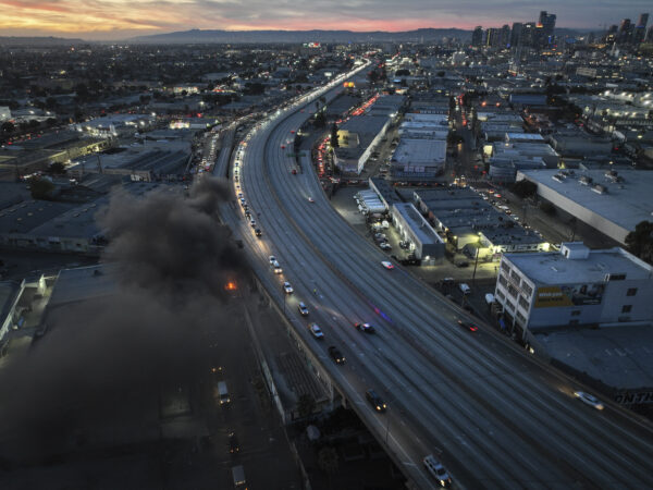 <b>LOS ANGELES — Still surreal — the continuing visions of an empty freeway in the middle of LA:</b> Smoke rises from a small fire as motorists exit through a ramp off Interstate 10, where a section of the freeway is closed due to a recent fire in Los Angeles, Tuesday, Nov. 14, 2023. It will take at least three weeks to repair the freeway damaged in an unrelated arson fire, the California governor said Tuesday, leaving the city already accustomed to soul-crushing traffic without part of a vital artery that serves hundreds of thousands of people daily.<br>Photo: Jae C. Hong/AP