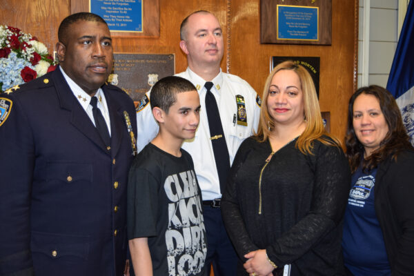 Jeffrey Maddrey (left), a law school student at Touro Law Center, with the Ramos family at a solemn ceremony at the NYPD's 84th Precinct, commemorating the life and service of Detective Rafael Ramos.