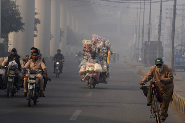 <b>PAKISTAN — Wishing it were fog and not smog, in the fourth worst polluted country in the world:</b> Vehicles and motorcyclists go through traffic on a road as heavy fog reduces visibility, in Lahore, Pakistan, Thursday, Nov. 16, 2023.<br>Photo: K.M. Chaudary/AP
