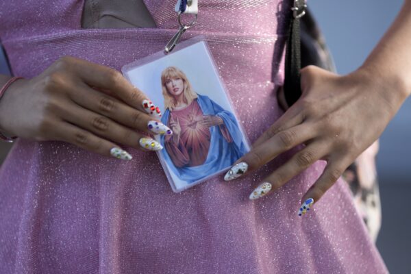 <b>ARGENTINA – How myths are spread – lots of westerners believed Jesus had blond hair:</b> A fan holds a prayer-like card simulating Taylor Swift as the Most Sacred Heart of Jesus before the start of The Eras Tour concert at the Monumental stadium in Buenos Aires, Argentina, Thursday, Nov. 9, 2023.<br>Photo: Natacha Pisarenko/AP