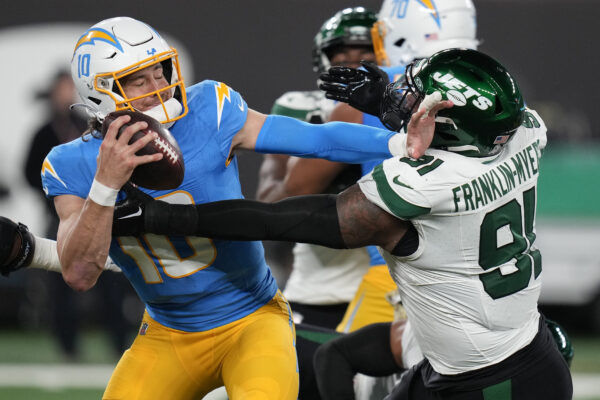<strong>NEW JERSEY — Long arms help when someone’s getting in your face:</strong> Los Angeles Chargers quarterback Justin Herbert (10) stiff-arms New York Jets defensive end John Franklin-Myers (91) during the second quarter of an NFL football game, Monday, Nov. 6, 2023, in East Rutherford, N.J.<br>Photo: Seth Wenig/AP