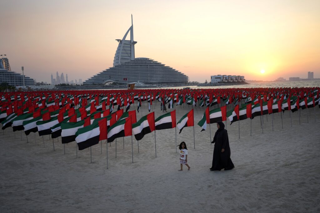 DUBAI — Key elements for Flag Day — the sun, the sand, new construction and six thousand flags: An Emirati mother walks with her daughter in front of six thousand flags on display to celebrate the country's Flag Day in Dubai, United Arab Emirates, Saturday, Nov. 4, 2023. The Emirates Flag Day is officially on Nov. 3. Photo: Kamran Jebreili/AP
