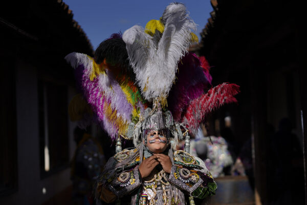 <b>GUATEMALA — Dressing up for the patron saint of a six-syllable town:</b> A dancer adjusts his costume before taking part in a procession honoring St. Thomas, the patron saint of Chichicastenango in Guatemala, Thursday, Dec. 21, 2023.<br>Photo: Moises Castillo/AP