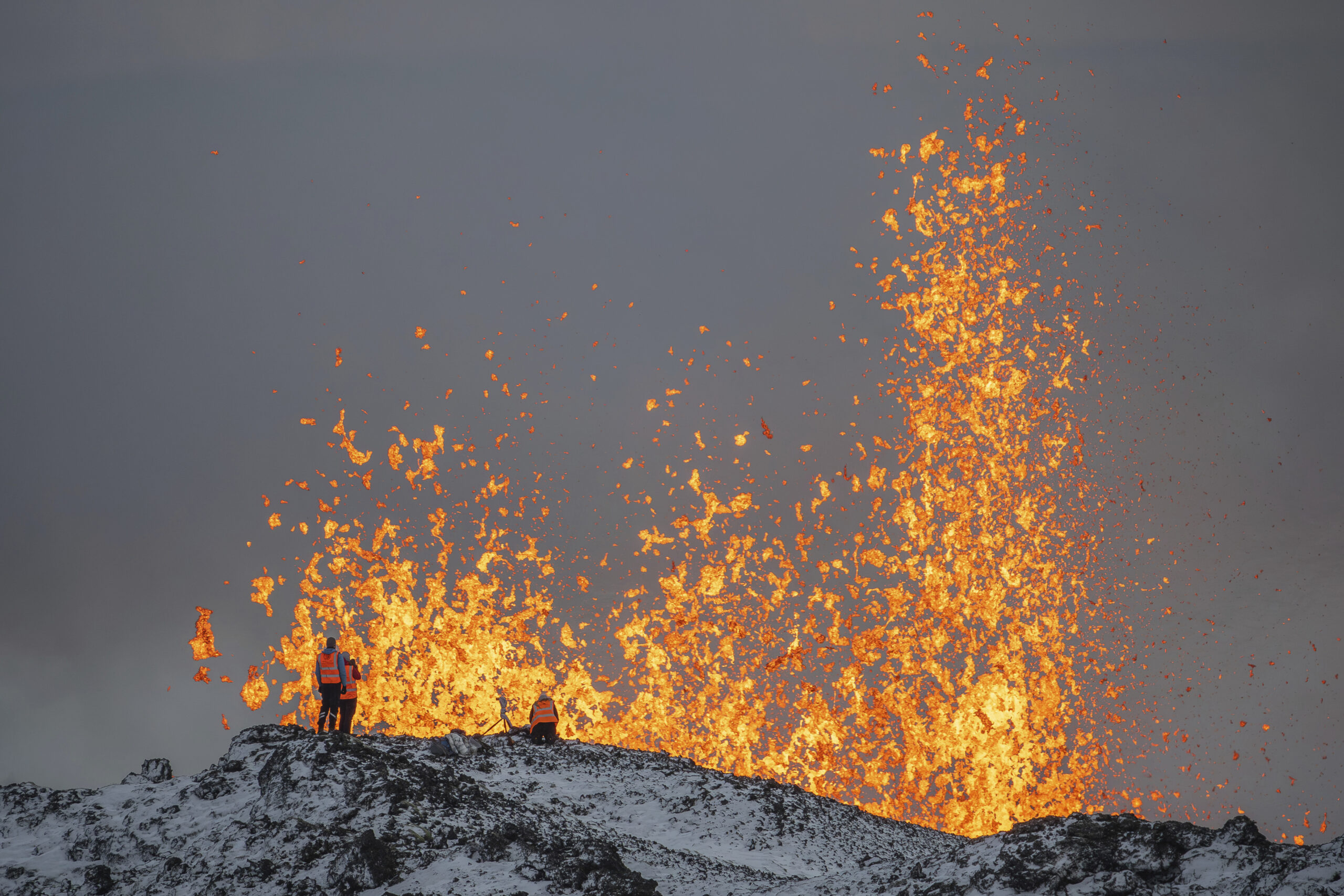 ICELAND — Brave men taking stock of Mother Nature’s power: Scientists from the University of Iceland take measurements and samples standing on the ridge in front of the active part of the eruptive fissure of an active volcano in Grindavik on Iceland's Reykjanes Peninsula, Tuesday, Dec. 19, 2023.Photo: Marco Di Marco/AP