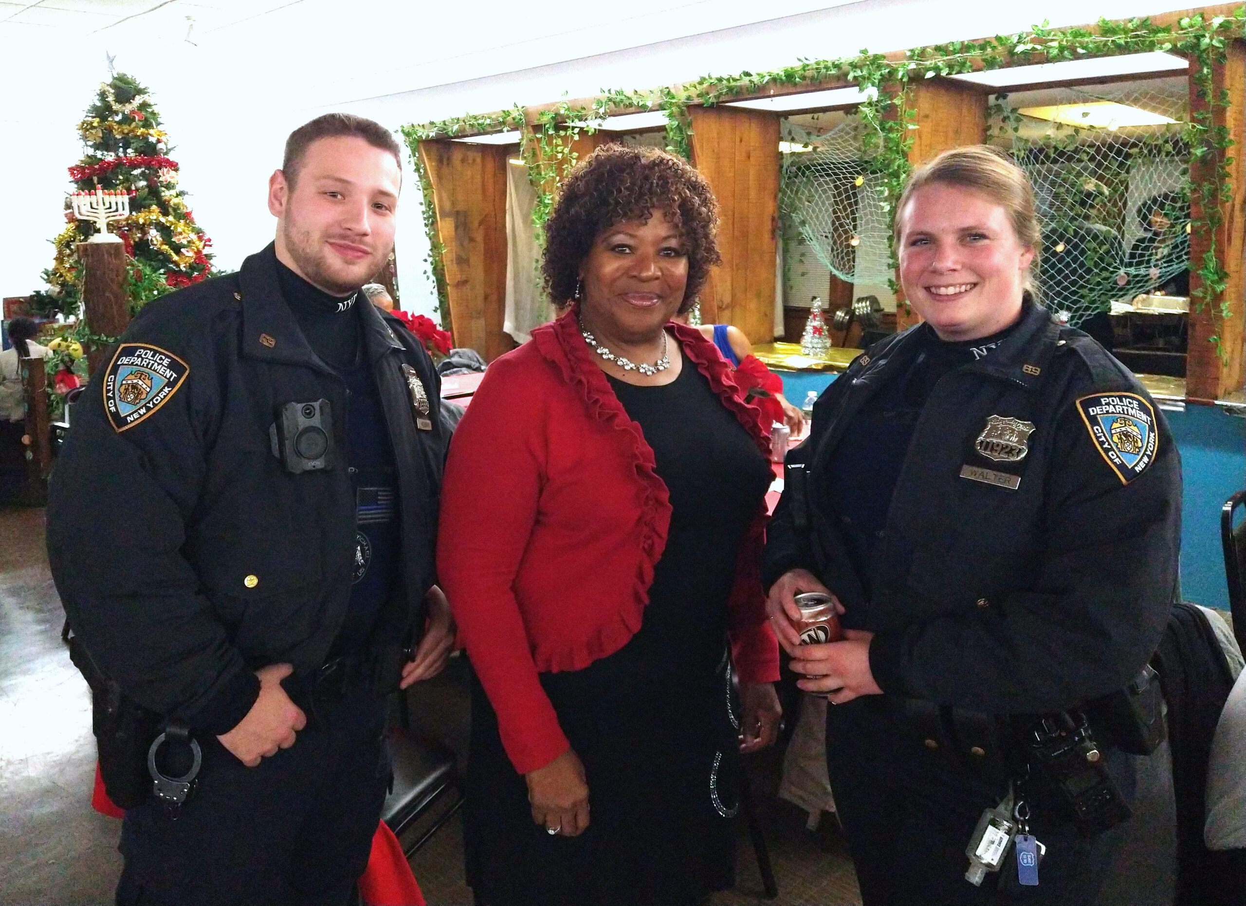 Maria Garrett, president, Fresh Creek Civic Association (center), with two of Brooklyn’s finest at 69th Precinct Community Council’s annual holiday celebration.