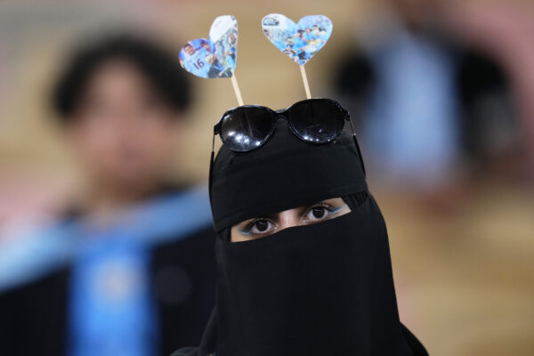 <b>SAUDI ARABIA — Burka hides facial emotion while creative, improvised art shows the love behind the sunglasses:</b> A Manchester City fan attends the trophy ceremony after the end of the Soccer Club World Cup final match between Manchester City FC and Fluminense FC at King Abdullah Sports City Stadium in Jeddah, Saudi Arabia, Friday, Dec. 22, 2023. Manchester City won 4-0.<br>Photo: Manu Fernandez/AP