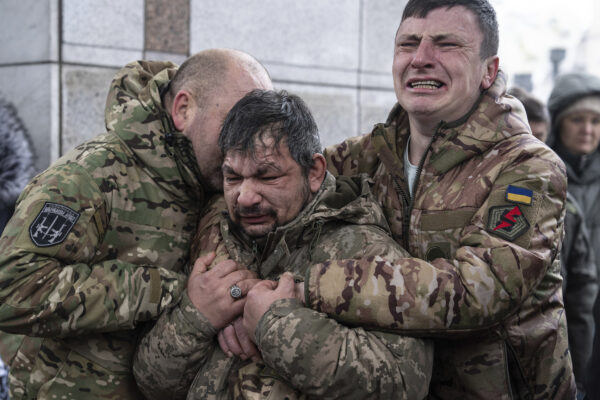<b>KYIV — Ukrainian pain and anguish:</b> Ukrainian servicemen cry near the coffin of their comrade Andrii Trachuk during his funeral service on Independence Square in Kyiv, Ukraine, Friday, Dec. 15, 2023. Trachuk was a veteran of the Revolution of Dignity and was killed by Russian forces on Dec. 9, 2023, near Kherson.<br>Photo: Evgeniy Maloletka/AP