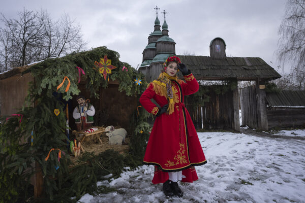 <b>KYIV — Celebrating an international holiday, even during conflict:</b> A woman dressed in national costume stands near the nativity scene to celebrate Christmas in the village of Pirogovo, outside the capital Kyiv, Ukraine, Monday, Dec. 25, 2023.<br>Photo: Efrem Lukatsky/AP