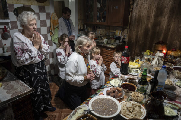 <b>UKRAINE — Quiet, reflective family celebration for Christmas dinner:</b> The Zelenchuk family prays before a Christmas dinner in Kryvorivnia village, Ukraine, on Sunday, Dec. 24, 2023.<br>Photo: Evgeniy Maloletka/AP