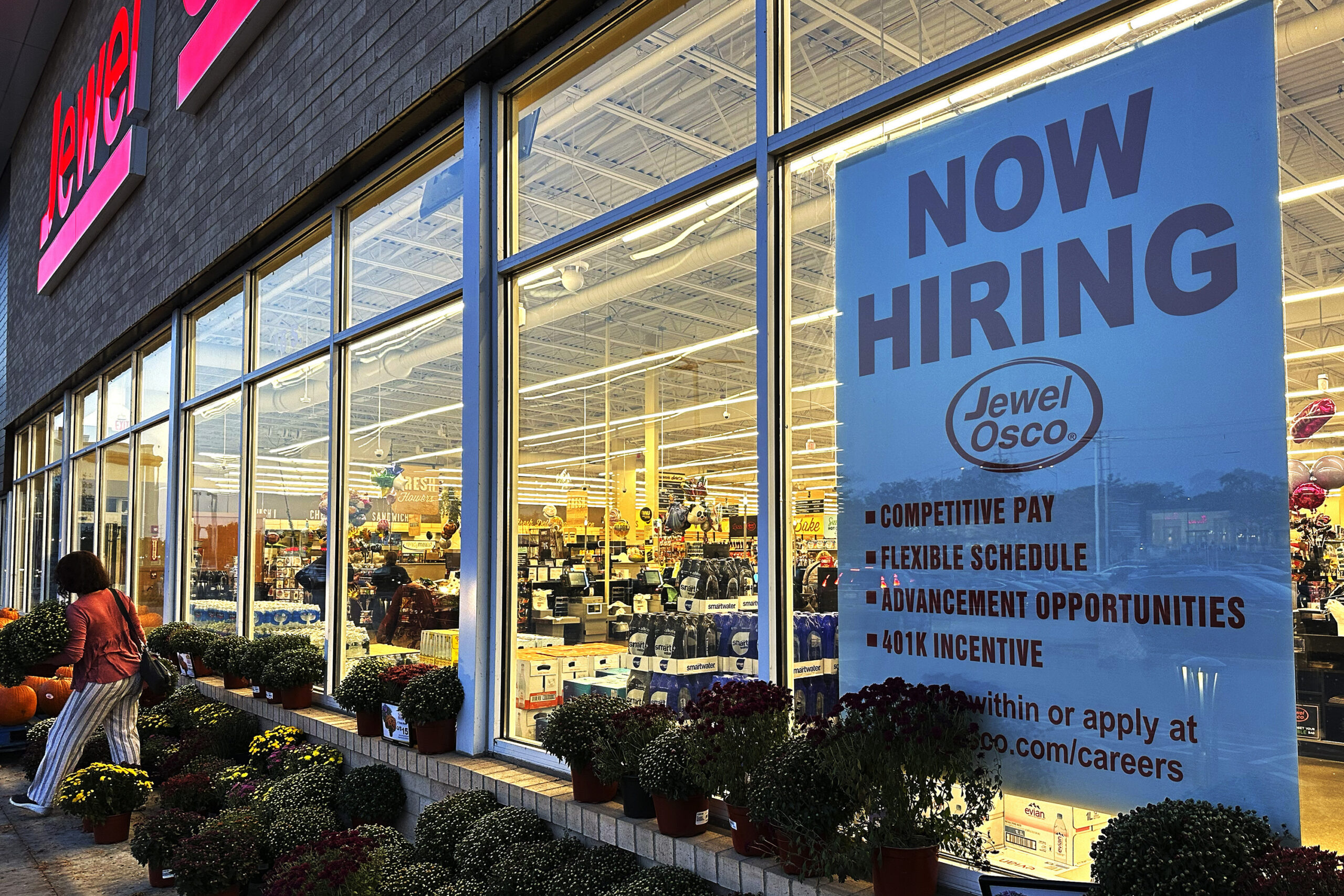 A hiring sign is displayed at a grocery store.