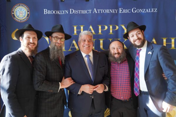 District Attorney Eric Gonzalez (center) is joined by prominent Jewish community leaders, including Rabbi Eliyahu Raskin, the rabbi for Jewish law students in Downtown Brooklyn (far right), and Rabbi Aaron Raskin (second from left).
