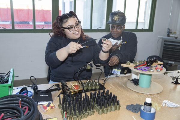 Ciera Morales Shameeka Simpson using soldering equipment at Pvilion ribbon cutting.