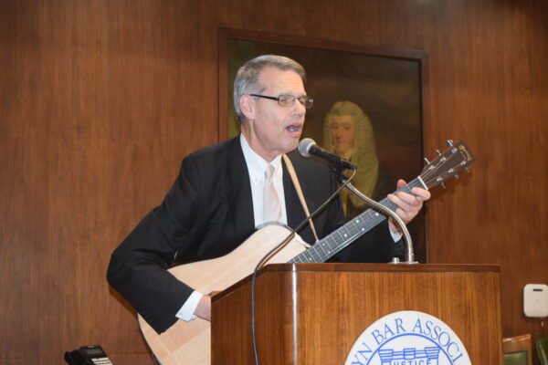 Justice Lawrence Knipel entertains the audience with his guitar skills, adding a musical flair to the BWBA’s annual Membership Party.