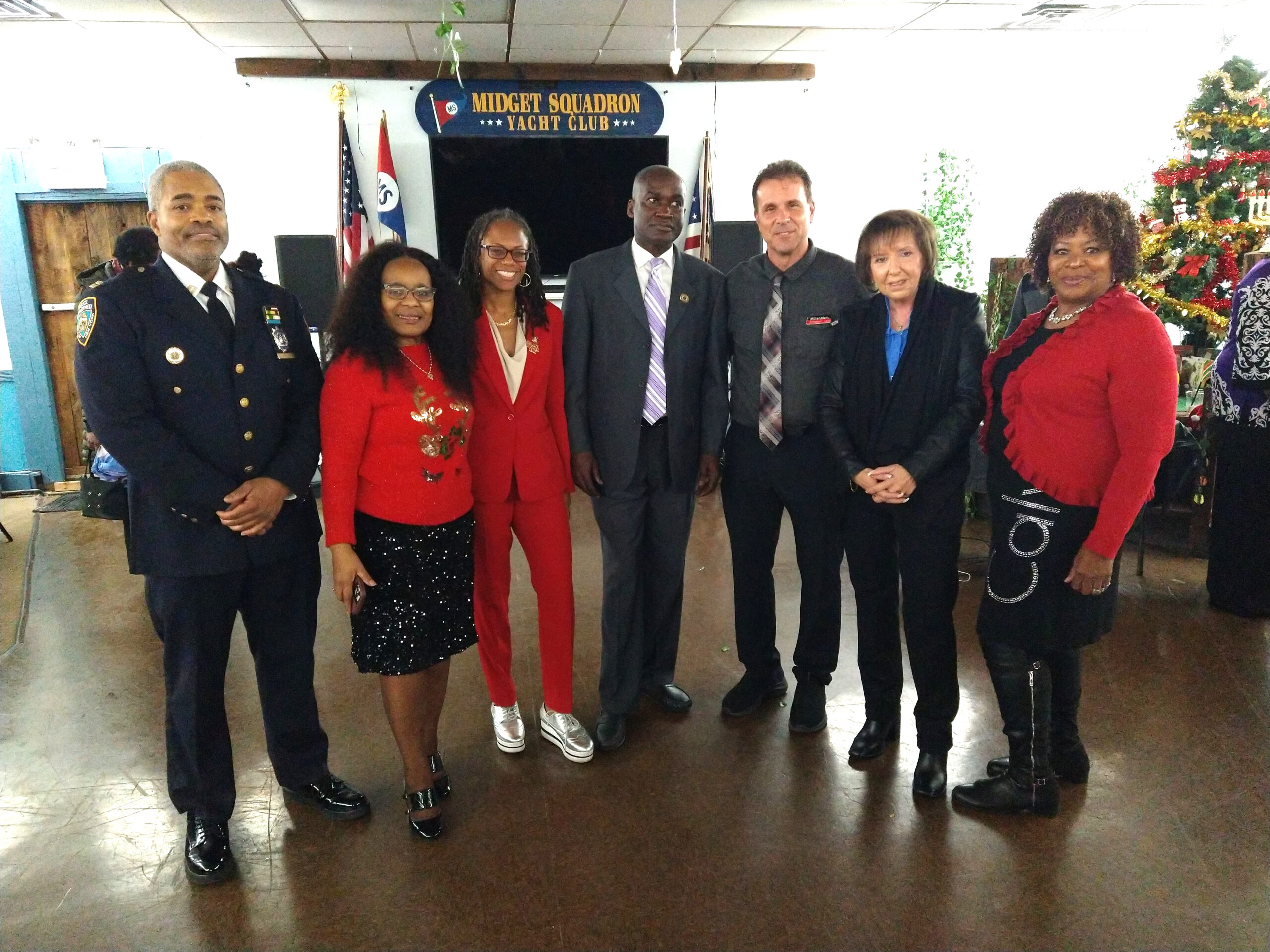 Gardy Brazela, president of the 69th Precinct Community Council (center) and guests at annual holiday celebration.