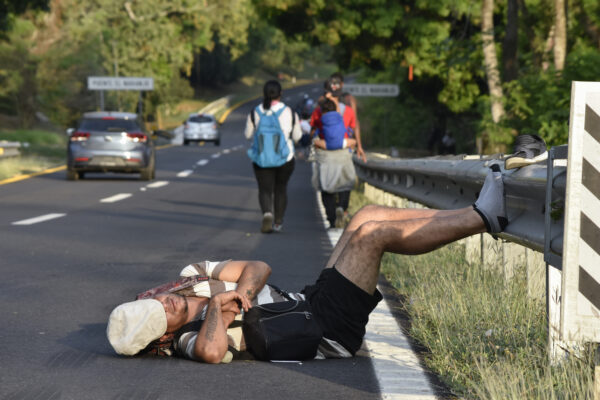 <b>MEXICO — Oh well, the right lane is probably better for road naps:</b> A migrant rests from walking north with a migrant caravan on a highway in Villa Comaltitlan, Chiapas state, southern Mexico, Wednesday, Dec. 27, 2023.<br>Photo: Edgar H. Clemente/AP