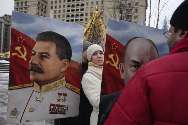 <b>MOSCOW — A thorn in Putin’s side, or just nostalgia:</b> A Communist Party supporter stands between portraits of Soviet leaders Joseph Stalin, left, and Vladimir Lenin on Manezhnaya Square decorated for the New Year and Christmas festivities near the Kremlin Wall in Moscow, Russia, Thursday, Dec. 21, 2023, marking the 144th anniversary of Stalin's birth.<br>Photo: Alexander Zemlianichenko/AP