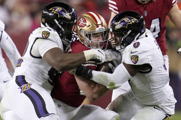 <b>CALIFORNIA — ‘Let’s show him what a real hug is like’:</b> San Francisco 49ers running back Christian McCaffrey, middle, is tackled by Baltimore Ravens defensive tackle Justin Madubuike, left, and linebacker Roquan Smith (0) during the second half of an NFL football game in Santa Clara, Calif., Monday, Dec. 25, 2023.<br>Photo: Godofredo A. Vásquez/AP