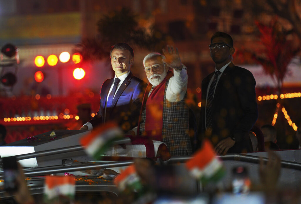 <b>INDIA — Political alliances and honors:</b> French President Emmanuel Macron, left, and Indian Prime Minister Narendra Modi, with his arm outstretched, ride an open vehicle together during a road show in Jaipur, Rajasthan, India, Thursday, Jan. 25, 2024. Macron will be the chief guest at India's annual Republic Day parade in New Delhi on Friday.<br>Photo: Deepak Sharma/AP