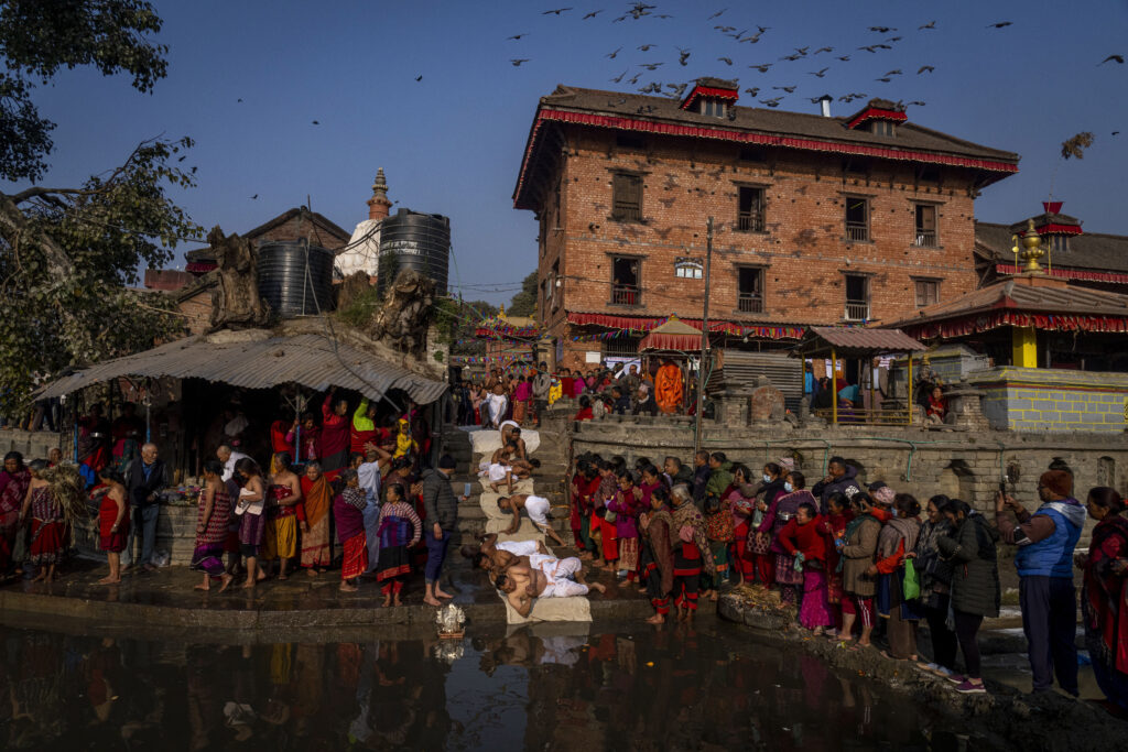 <b>NEPAL — A full moon will kick off the month-long festivities, beginning with a holy bath:</b> Hindu devotees perform rituals by the Hanumante River during the Madhav Narayan festival in Bhaktapur, Nepal, Thursday, Jan. 25, 2024.<br>Photo: Niranjan Shrestha/AP
