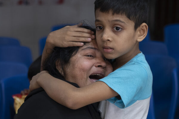 <b>BANGLADESH — Violent aftermath of a parliamentary vote:</b> Rakibul, 6, comforts his mother, Rehana, mourning the death of her husband, Mohammad Zillur, at a hospital in Munshiganj, outside Dhaka, Bangladesh, Sunday, Jan. 7, 2024. Zillur, a supporter of a candidate from the ruling Awami League, was stabbed to death on Sunday as Bangladesh voted in a parliamentary election boycotted by the main opposition party.<br>Photo: Altaf Qadri/AP