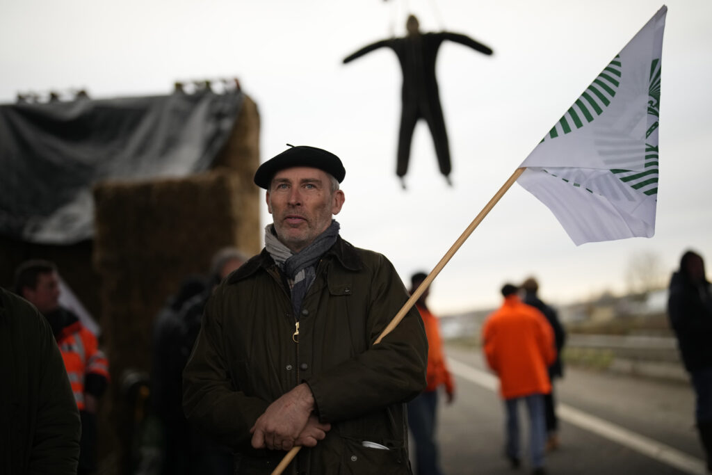 FRANCE — Barricading in a beret: A farmer stands at a barricade as farmers block a highway Tuesday, Jan. 30, 2024, in Jossigny, east of Paris. With protesting farmers camped out at barricades around Paris, France's government hoped to calm their anger with more concessions Tuesday to their complaints that growing and rearing food has become too difficult and not sufficiently lucrative.Photo: Christophe Ena/AP