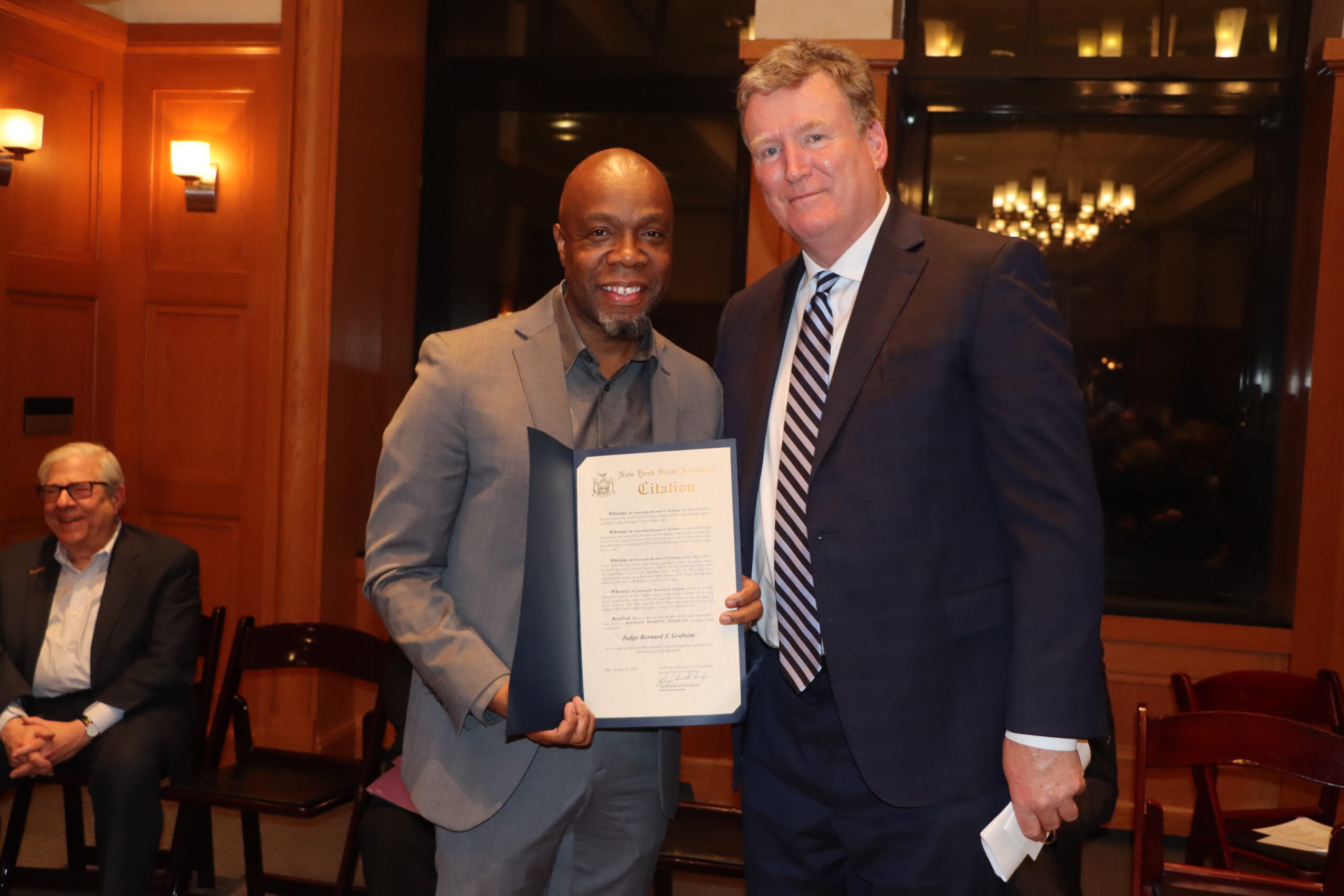 District Leader Henry Butler presents Surrogate Bernard Graham with a citation on behalf of Democratic Party Chair Rodneyse Bichotte Hermelyn at Graham's swearing-in.