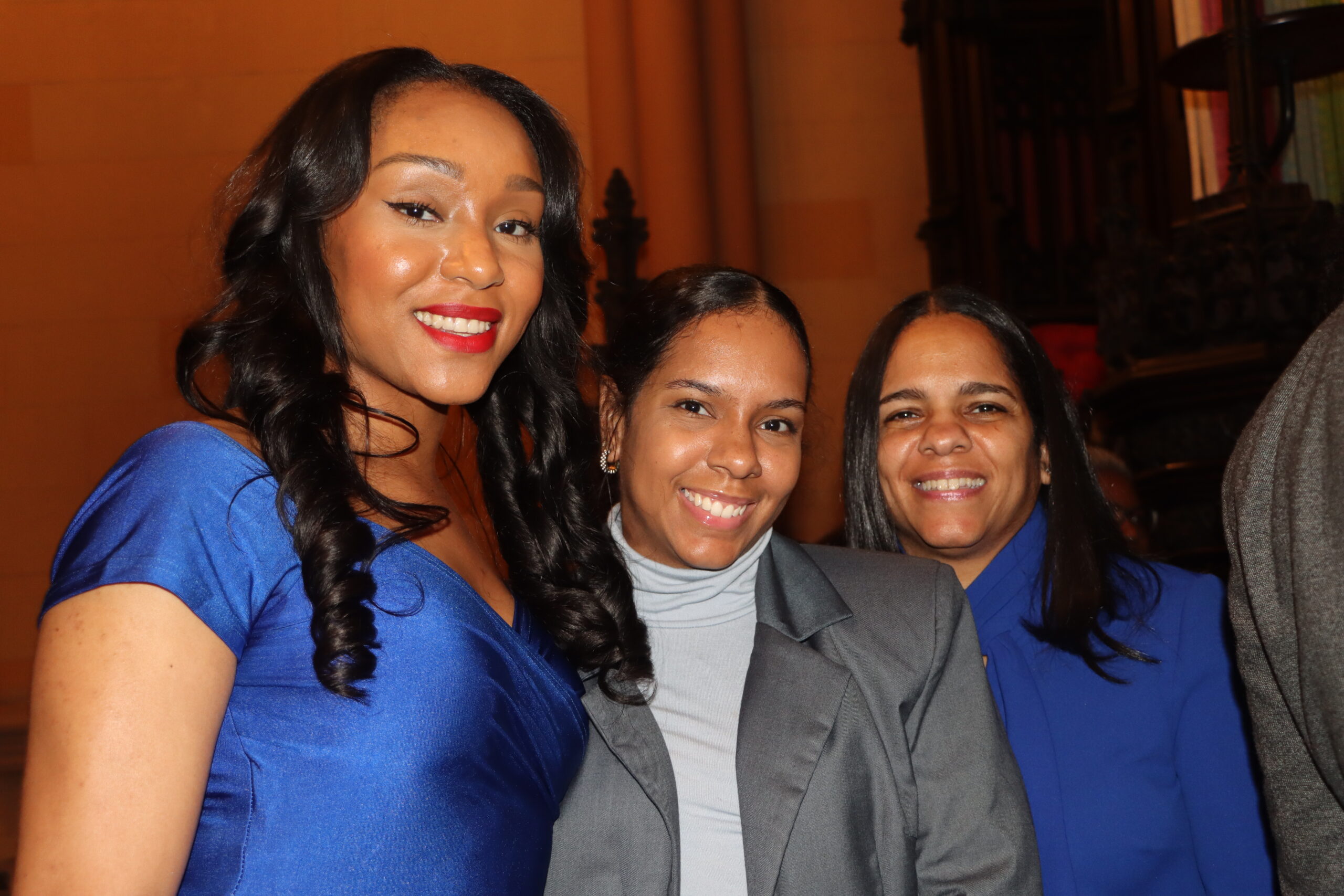 A candid capture of three of Judge Linda Wilson's children, showcasing the personal joy and family support behind her professional achievements at Linda Wilson's swearing-in.