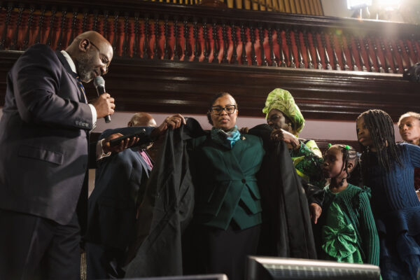 Hon. Lola Waterman dons her judicial robe for the first time, symbolizing her new role as a Civil Court judge.