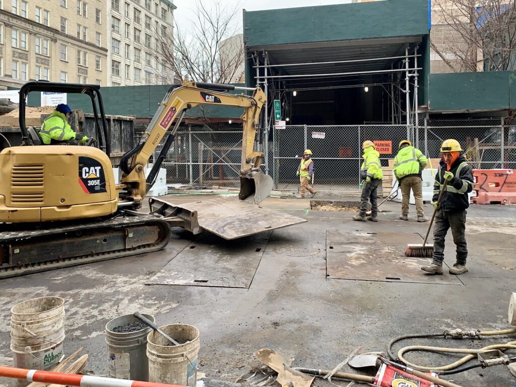 Workers dig multiple holes in Clark Street in Brooklyn Heights