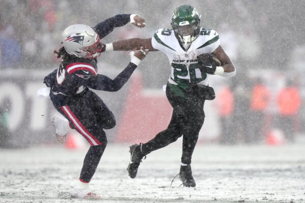 <b>MASSACHUSETTS — The classic, offensive ‘stiff-arm’ still works:</b> New York Jets running back Breece Hall (20) pushes away New England Patriots safety Kyle Dugger on a run during the first half of an NFL football game, Sunday, Jan. 7, 2024, in Foxborough, Mass.<br>Photo: Steven Senne/AP