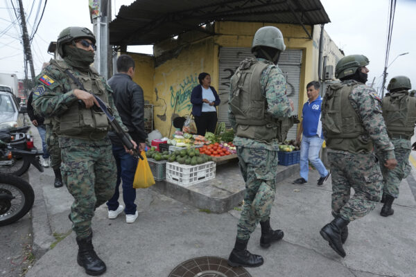 ECUADOR — Gang leader on the loose leads to lockdown: Soldiers patrol the perimeter of Inca prison during a state of emergency as a food vendor works on the sidewalk in Quito, Ecuador, Tuesday, Jan. 9, 2024, in the wake of the apparent escape of a powerful gang leader from prison. President Daniel Noboa decreed Monday a national state of emergency, a measure that lets authorities suspend people’s rights and mobilize the military in places like the prisons. The government also imposed a curfew from 11 p.m. to 5 a.m.Photo: Dolores Ochoa/AP